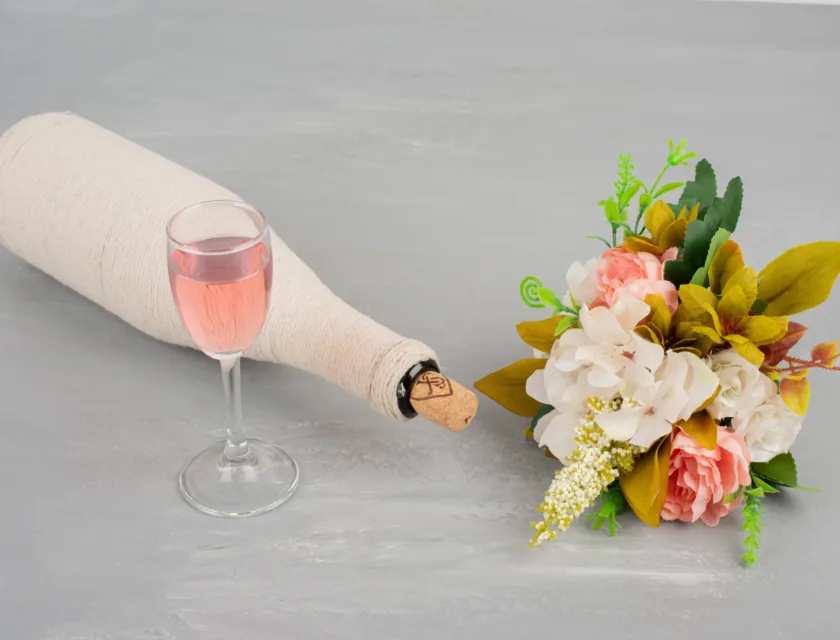 Bouquet of flowers and a glass of rose wine on grey surface