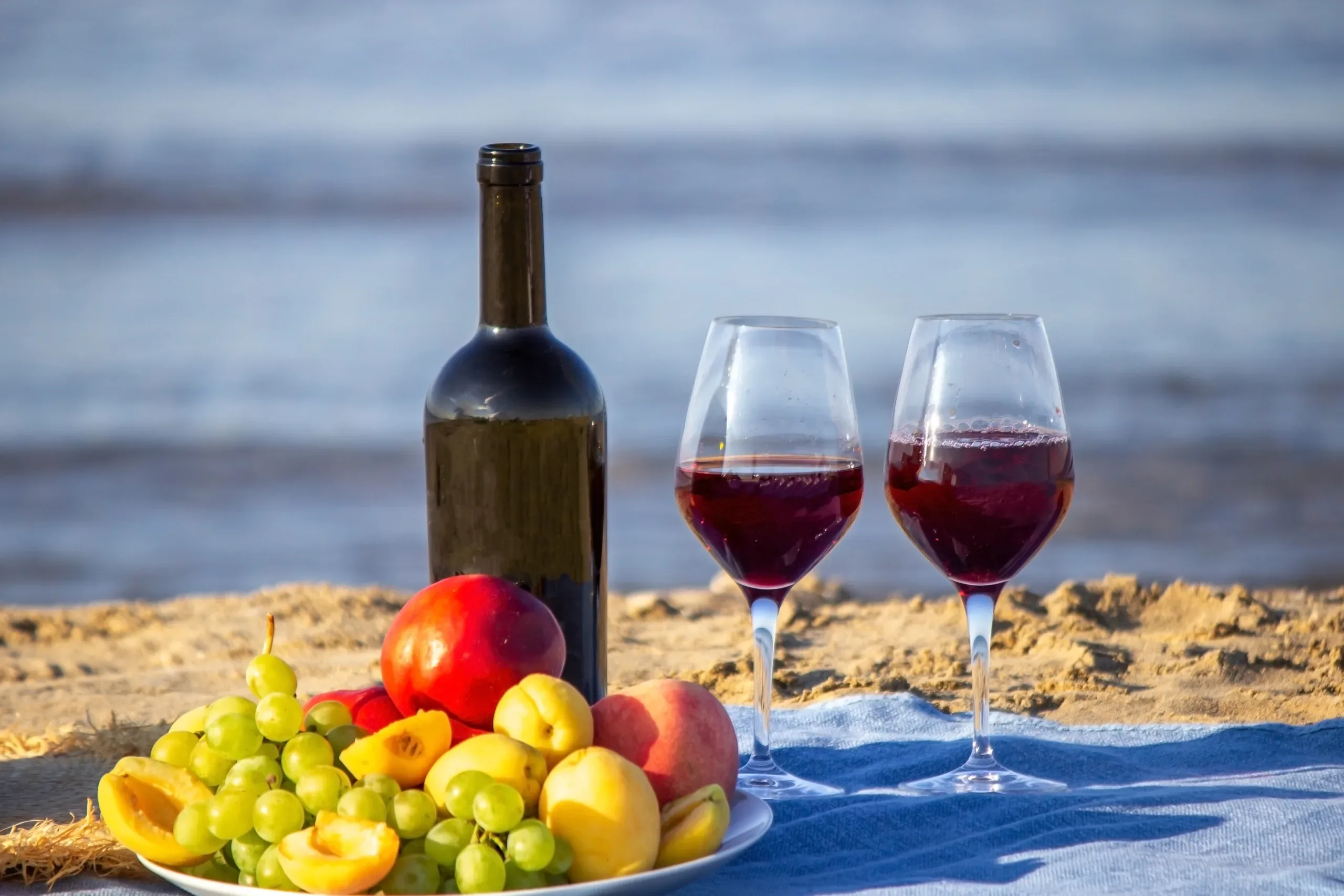 Picnic wine for summer season, wine, fruit, beautiful sea beach. Selective focus